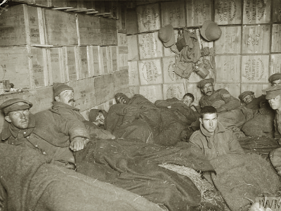 Frost-bitten soldiers lying on straw in shelters constructed of biscuit boxes at a store dump at Suvla, after the frost at the end of November 1915.