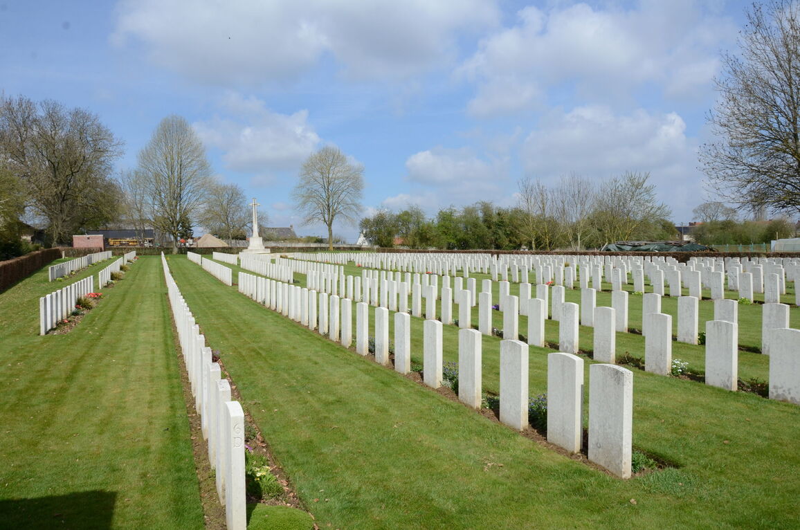 Beautifully aligned lines of white stone commonwealth graves at Roclincourt Military Cemetery, France, surrounded by green borders
